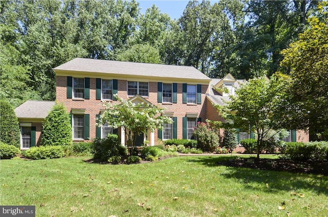 colonial house with a front yard and brick siding