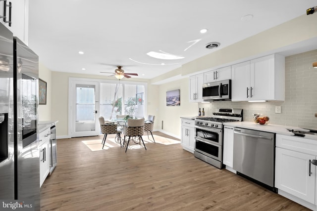 kitchen featuring light wood-style floors, tasteful backsplash, visible vents, and stainless steel appliances