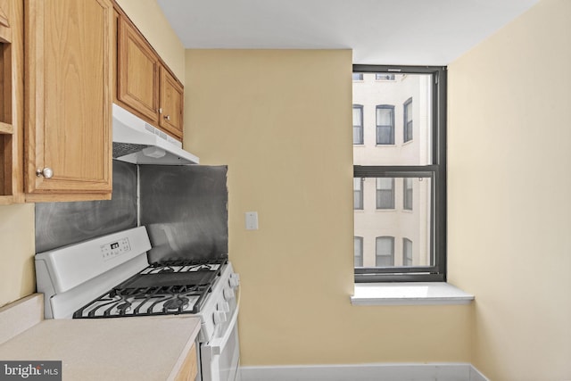 kitchen with white gas range oven and a wealth of natural light