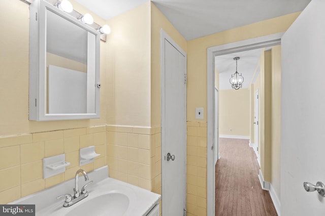 bathroom featuring hardwood / wood-style flooring, sink, and tile walls