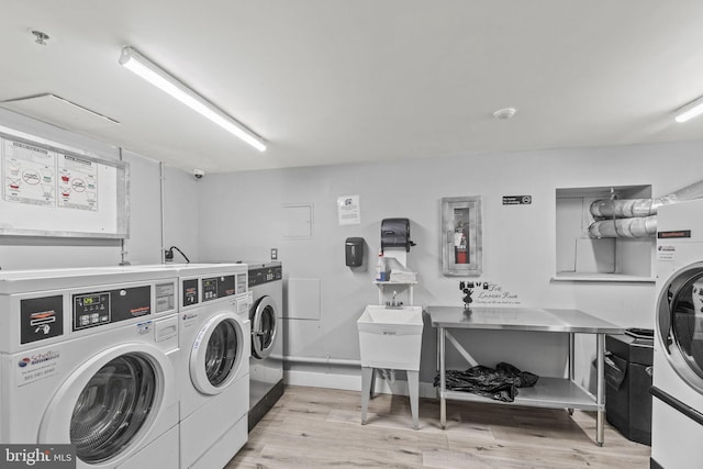 washroom with separate washer and dryer and light hardwood / wood-style flooring