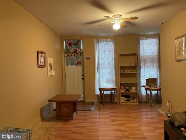 interior space with baseboards and a ceiling fan