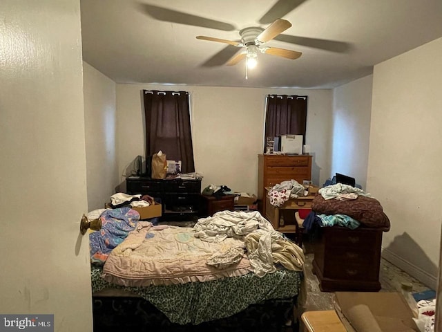 bedroom with a ceiling fan and baseboards