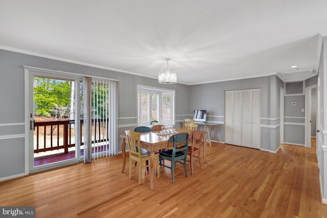 dining area with a notable chandelier, light hardwood / wood-style flooring, and ornamental molding