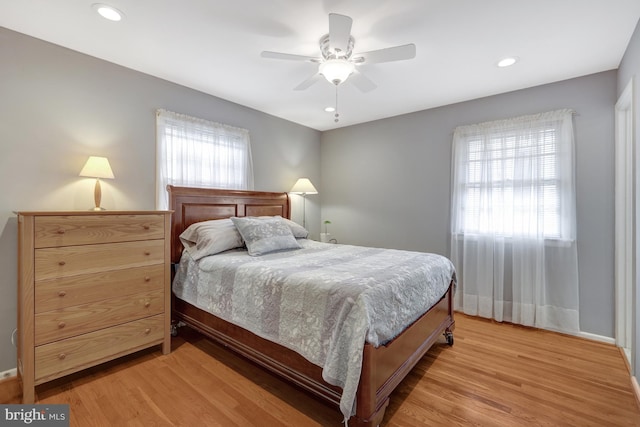 bedroom with multiple windows, ceiling fan, and light hardwood / wood-style flooring