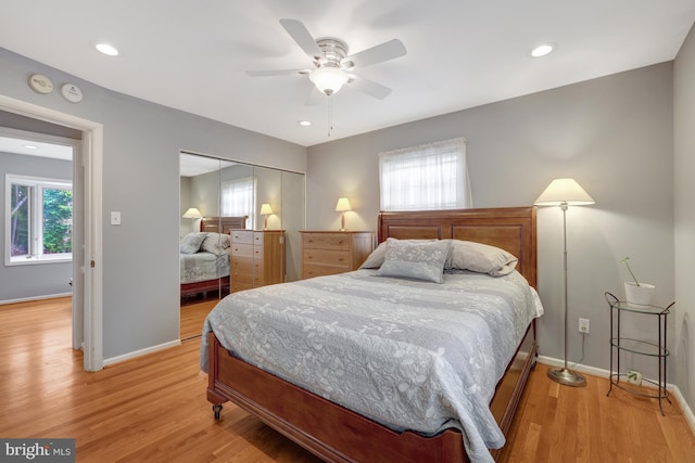 bedroom featuring light wood-type flooring, a closet, and multiple windows