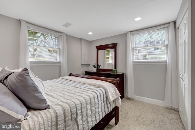 bedroom featuring light carpet and a closet