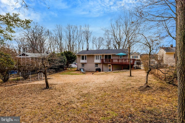 rear view of property with a yard and a wooden deck