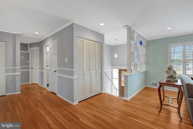 interior space with ornamental molding and light hardwood / wood-style flooring