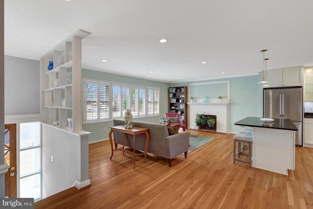 living room featuring light hardwood / wood-style floors and a brick fireplace