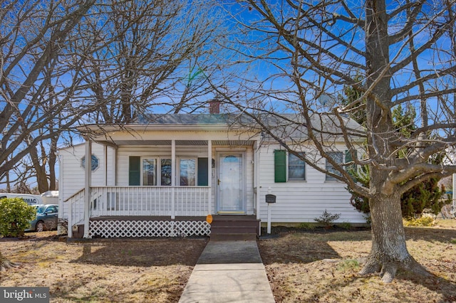 view of front of home with covered porch and a chimney