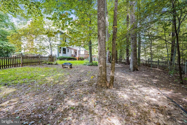 view of yard featuring a fenced backyard and a fire pit