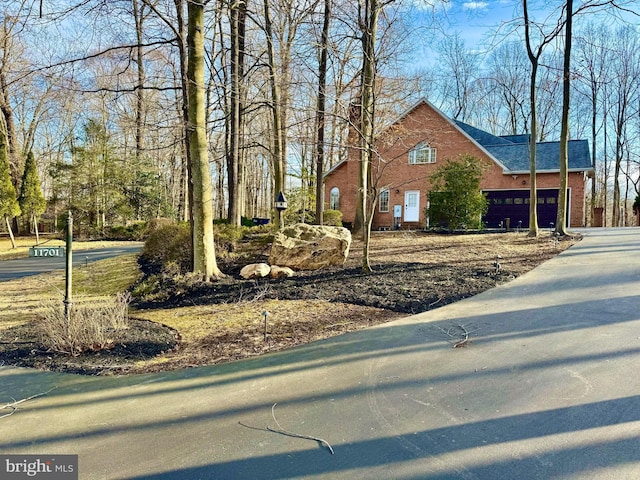 view of property exterior with concrete driveway and brick siding