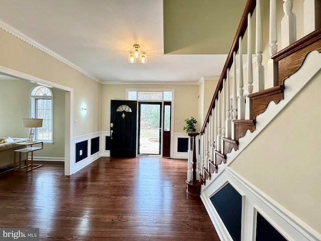 entryway featuring ornamental molding, dark wood-style flooring, wainscoting, and stairway