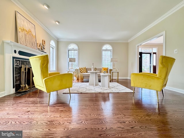 living area with ornamental molding, a fireplace, dark wood finished floors, and baseboards