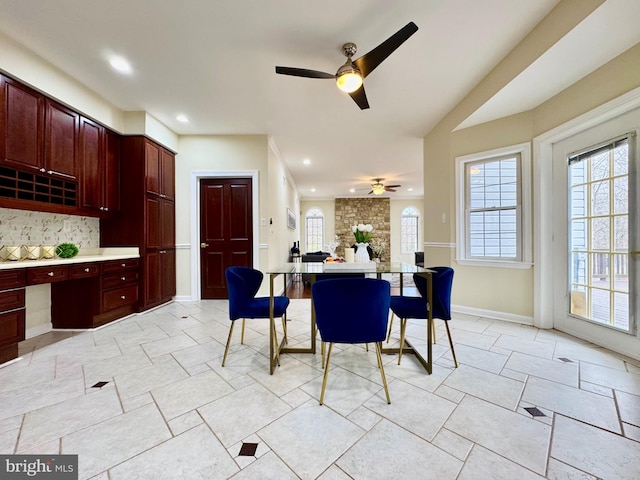 dining room featuring recessed lighting, built in study area, a ceiling fan, and baseboards