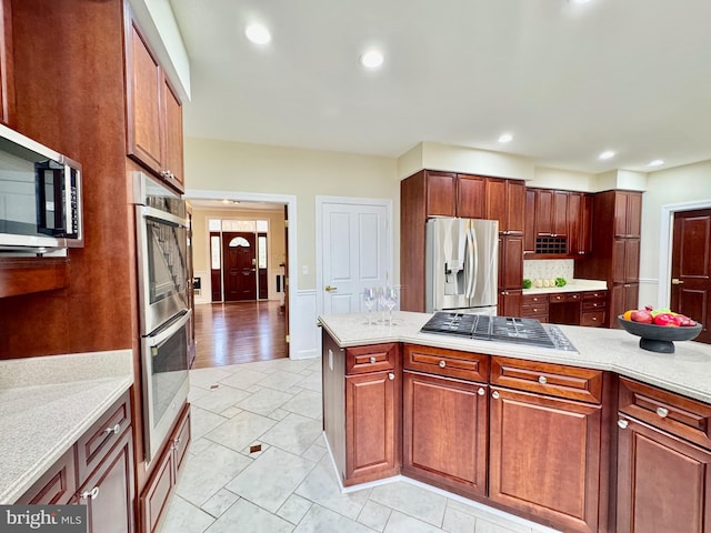 kitchen featuring tasteful backsplash, appliances with stainless steel finishes, light stone counters, and recessed lighting