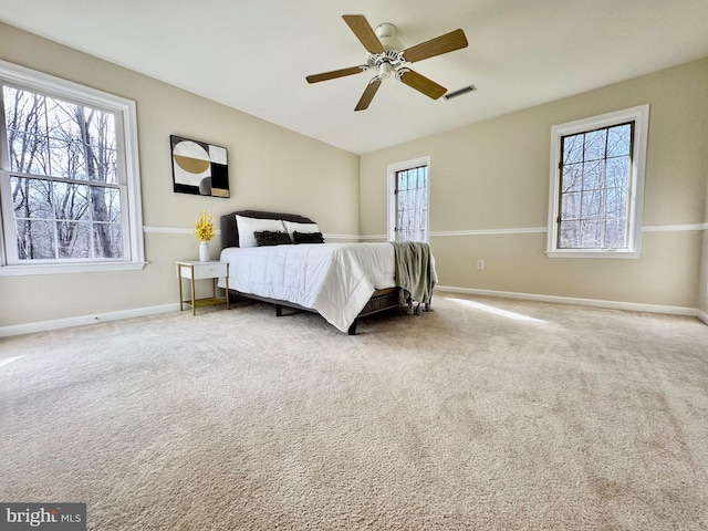 carpeted bedroom featuring baseboards, visible vents, and a ceiling fan