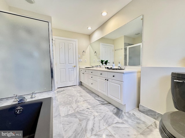 bathroom featuring marble finish floor, double vanity, a sink, and a shower stall