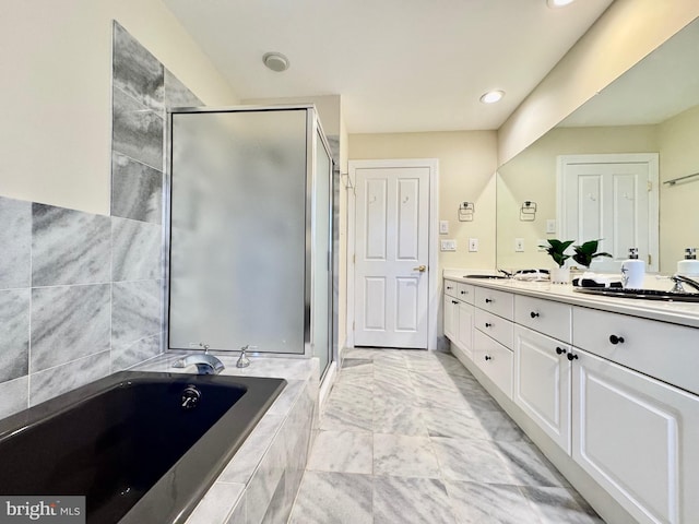 bathroom with a stall shower, a garden tub, a sink, and double vanity