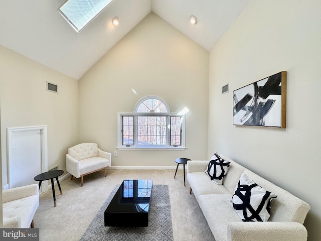 carpeted living area with high vaulted ceiling, a skylight, visible vents, and baseboards