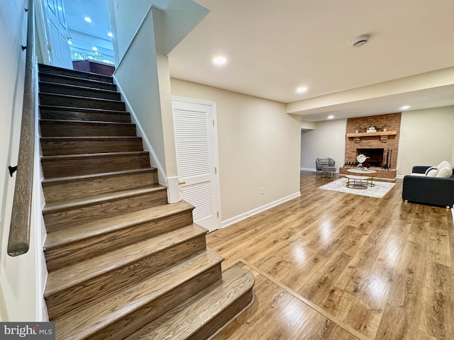 interior space with recessed lighting, a fireplace, wood finished floors, and baseboards