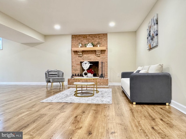 living area with recessed lighting, a brick fireplace, wood finished floors, and baseboards