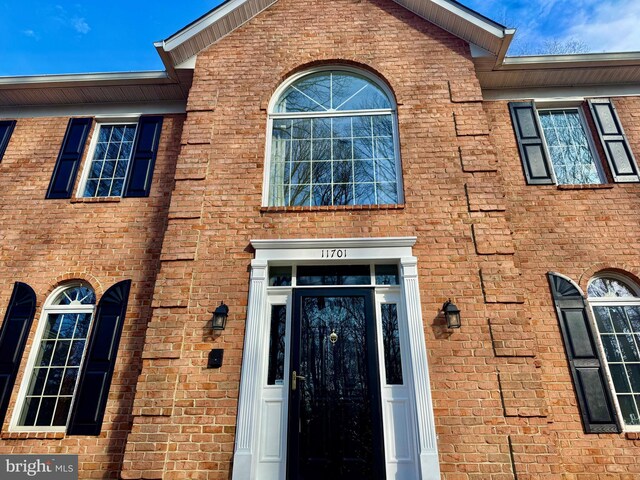 entrance to property featuring brick siding