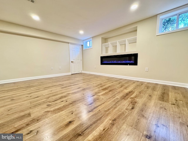 unfurnished living room featuring light wood-type flooring, baseboards, and recessed lighting