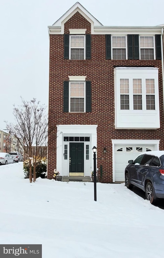 view of front facade with a garage and brick siding