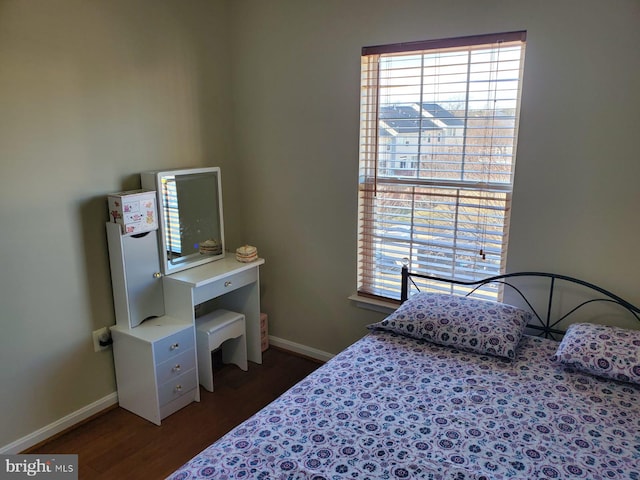 bedroom featuring dark wood-type flooring, multiple windows, and baseboards