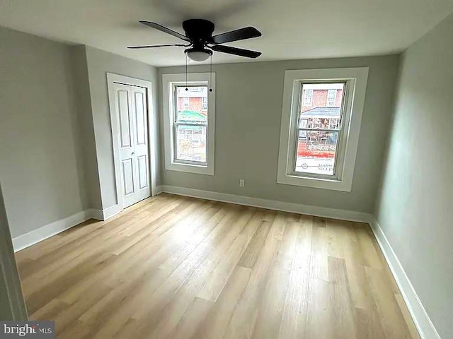 unfurnished bedroom with ceiling fan, light hardwood / wood-style flooring, and a closet