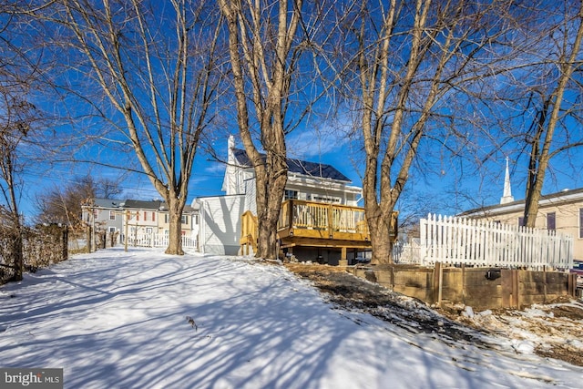 snow covered house featuring a deck