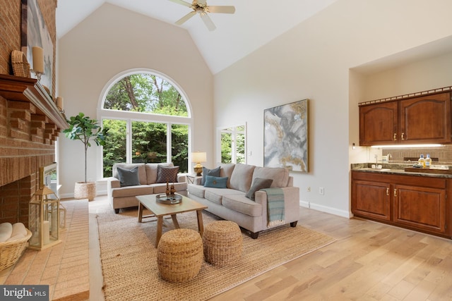 10928 Woodland Falls Dr, Great Falls, VA 22066 - living area featuring high vaulted ceiling, light wood-type flooring, a ceiling fan, a fireplace, and baseboards