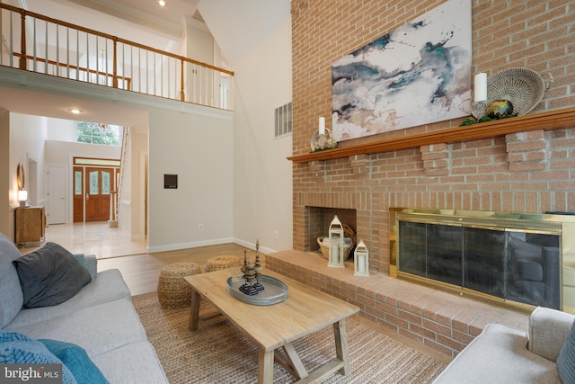 10928 Woodland Falls Dr, Great Falls, VA 22066 - living area featuring a brick fireplace, baseboards, a towering ceiling, and wood finished floors