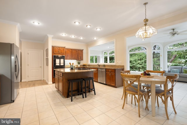 10928 Woodland Falls Dr, Great Falls, VA 22066 - kitchen featuring appliances with stainless steel finishes, brown cabinets, a kitchen island, crown molding, and pendant lighting