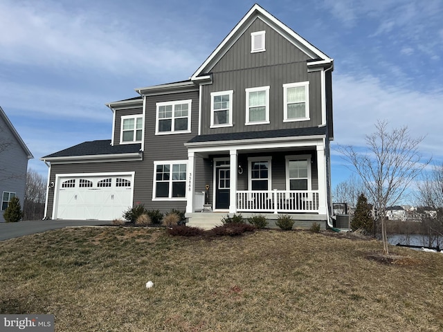 view of front of home featuring a front lawn, central air condition unit, a garage, and a porch