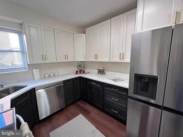 kitchen featuring dark wood-style flooring, stainless steel appliances, dark cabinets, and white cabinets