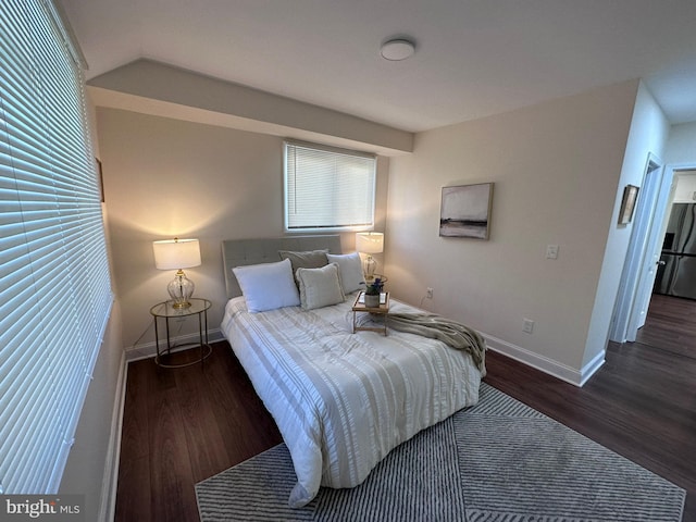 bedroom with freestanding refrigerator, baseboards, and wood finished floors