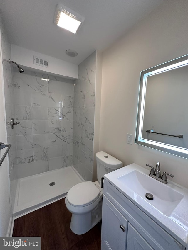 bathroom featuring vanity, wood finished floors, visible vents, and a shower stall