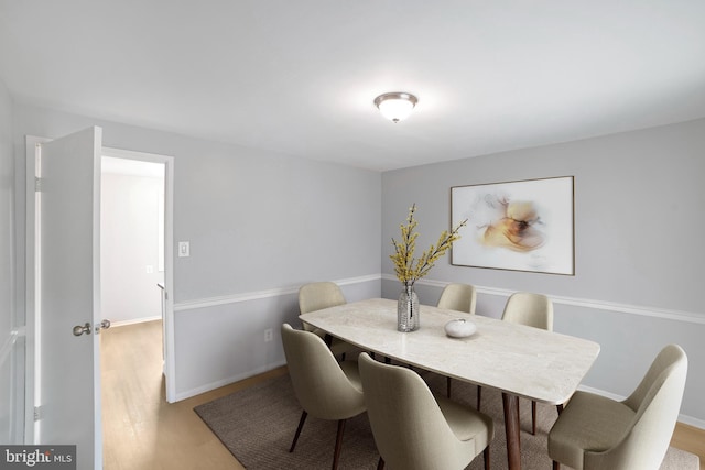 dining room featuring light wood finished floors and baseboards