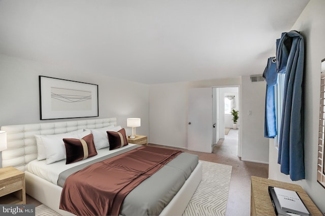 bedroom featuring visible vents and light colored carpet