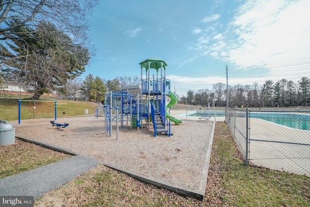 community playground featuring fence and a community pool