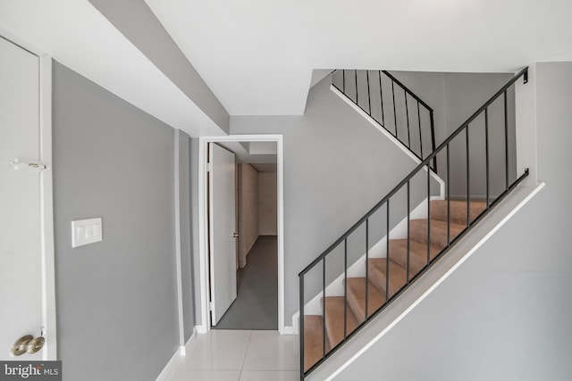 staircase with tile patterned flooring and baseboards