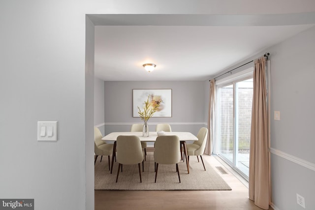 dining room with a healthy amount of sunlight, visible vents, and wood finished floors