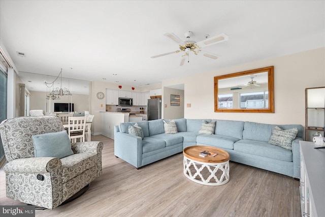 living room with ceiling fan and light hardwood / wood-style floors