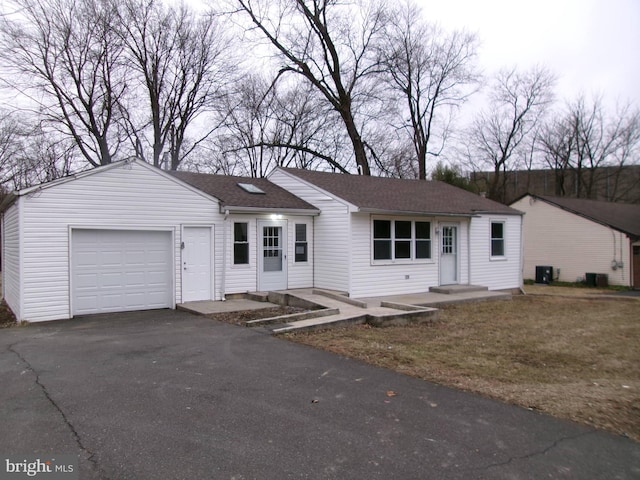 ranch-style home featuring a garage and cooling unit