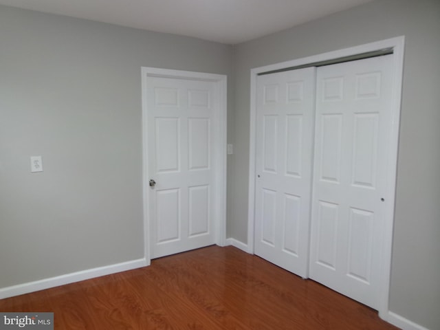 unfurnished bedroom featuring a closet and wood-type flooring