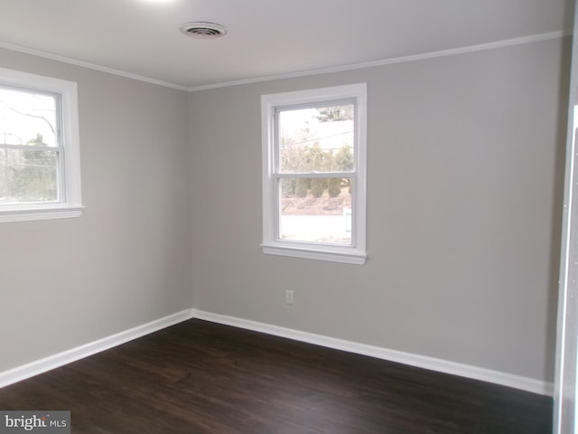 empty room with a wealth of natural light, dark hardwood / wood-style flooring, and ornamental molding