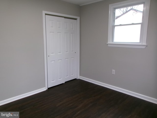 unfurnished bedroom featuring a closet and dark hardwood / wood-style floors